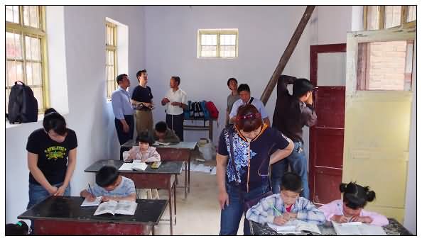 3. 志愿者们有的关心孩子们的学习，有的商量安装照明、吊扇方案