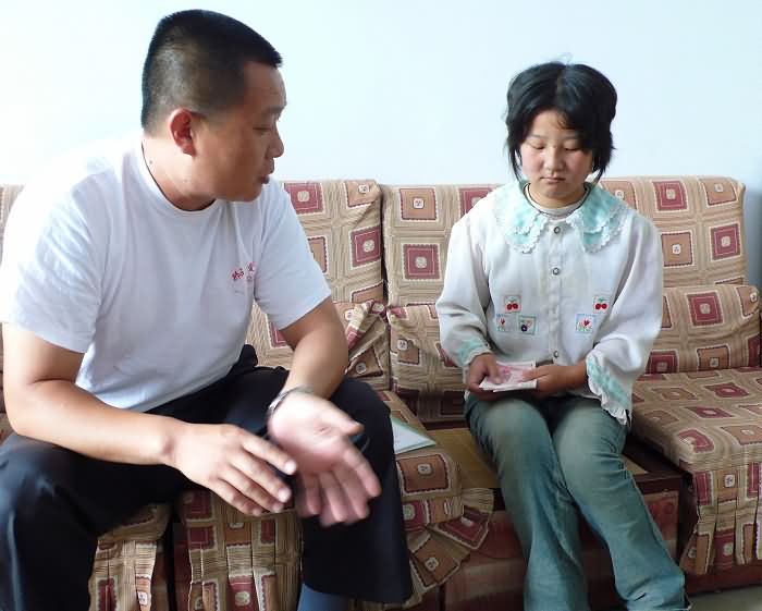在浆水镇中心学校，代“明镜非台”向王芸、王盛姐弟转交助学款600元