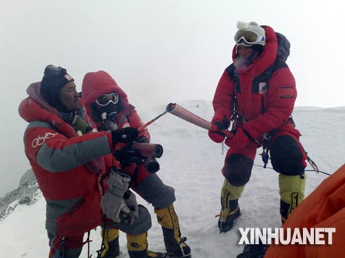 5月8日，北京奥运圣火珠峰传递登山队成功登顶珠峰。这是罗布占堆（左）点燃第一棒火炬手吉吉手中的“祥云”