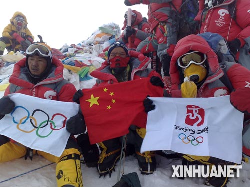 这是登山队员在峰顶展示中国国旗、奥运五环旗和北京奥运会会徽旗。