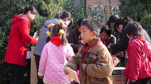 8.志愿者为学生发学习用品.jpg