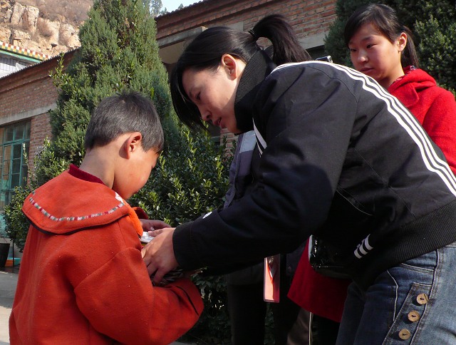 9.志愿者为学生发学习用品.jpg